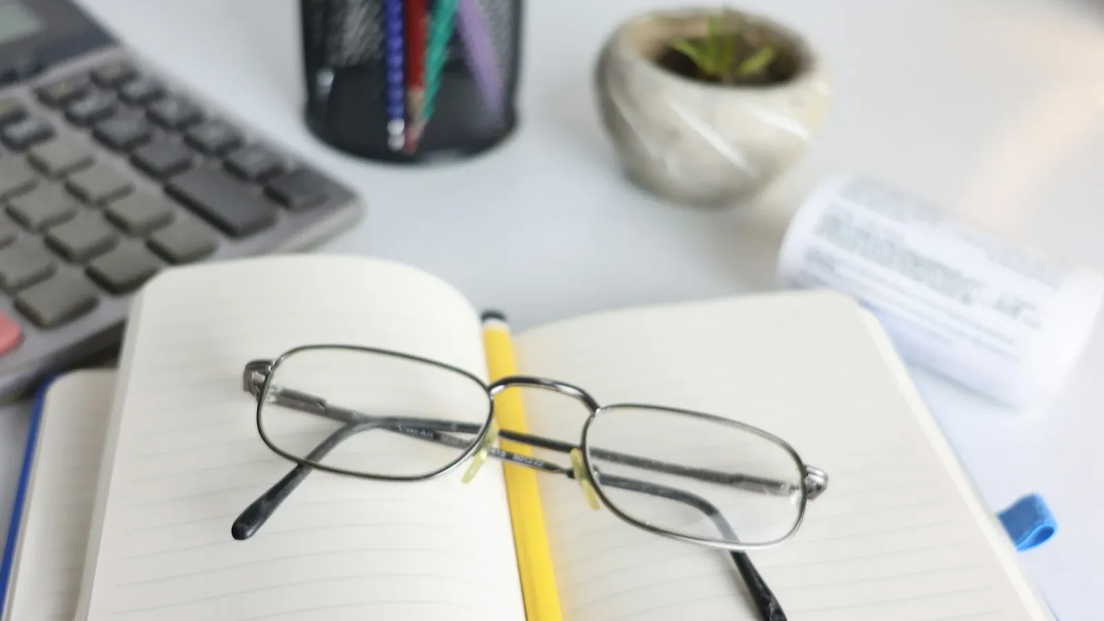 Anteojos apoyados sobre un cuaderno abierto