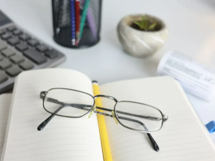 Anteojos apoyados sobre un cuaderno abierto