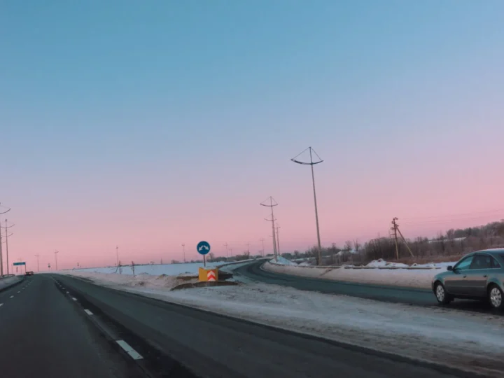 Auto circulando por una carretera al atardecer