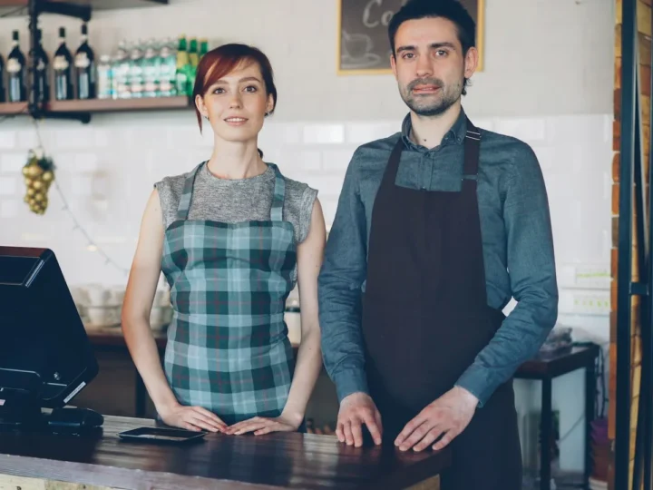 Dos trabajadores atendiendo detrás del mostrador de un café
