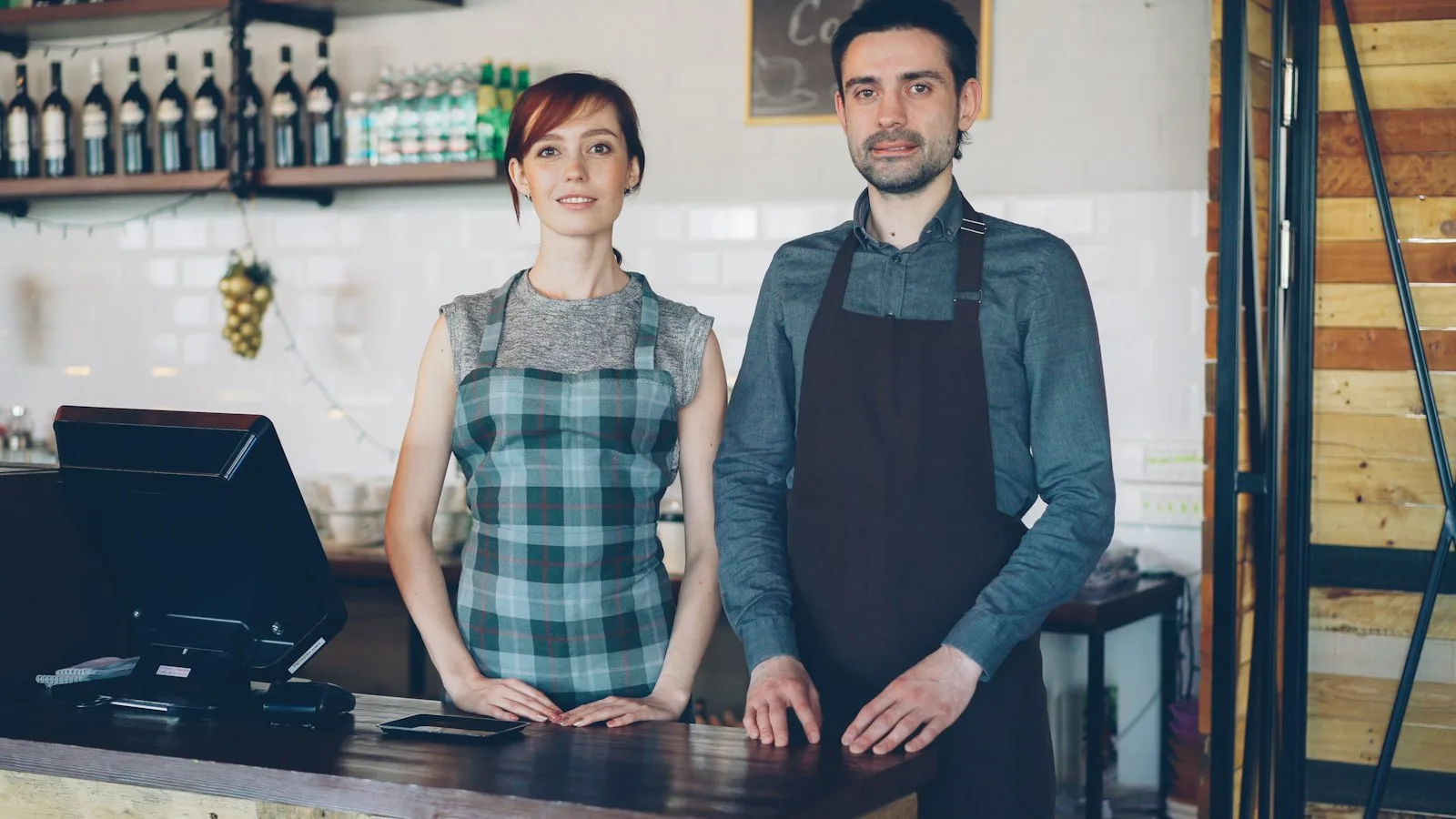 Dos trabajadores atendiendo detrás del mostrador de un café