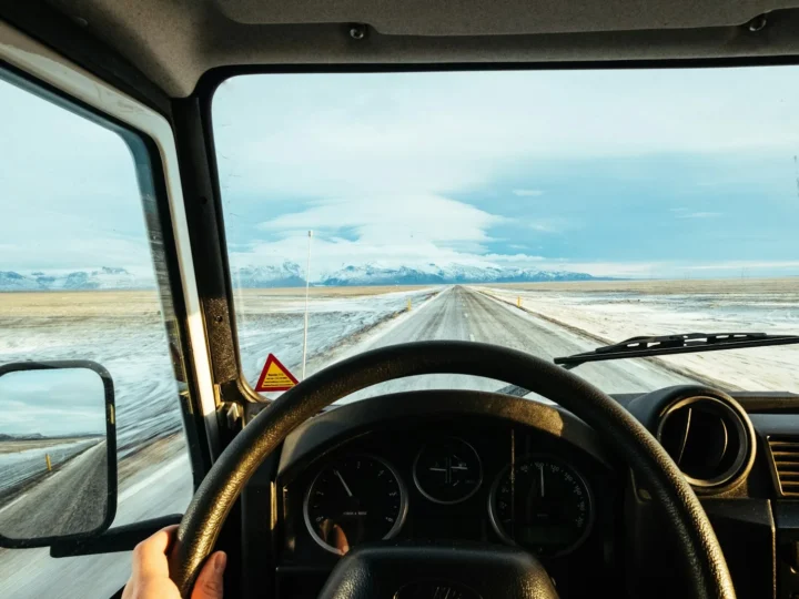 Persona conduciendo por una ruta al atardecer