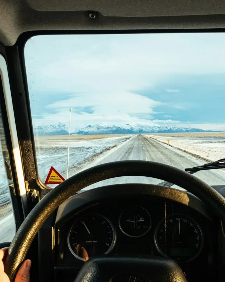 Persona conduciendo por una ruta al atardecer