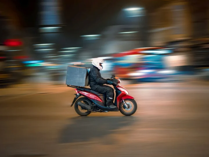 Repartidor en scooter circulando por la ciudad