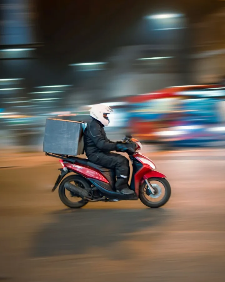 Repartidor en scooter circulando por la ciudad