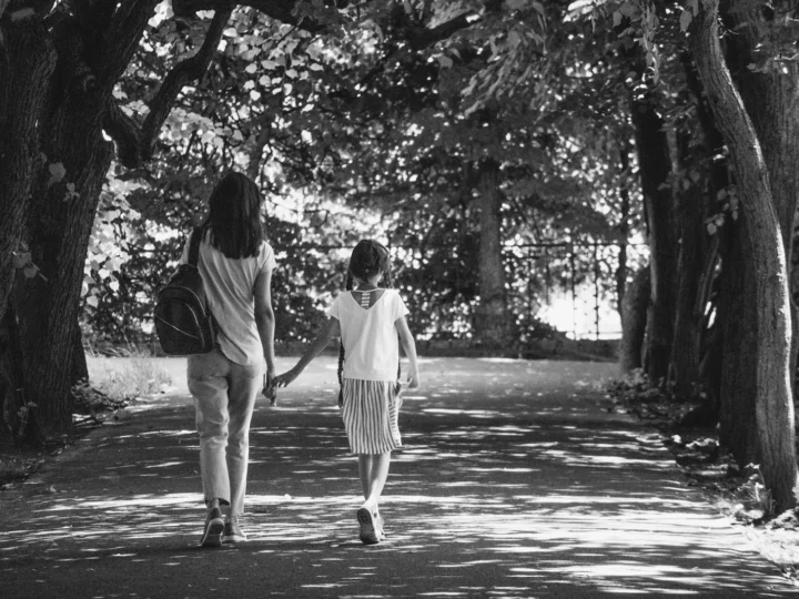 Una mujer y un niño caminando por un sendero arbolado