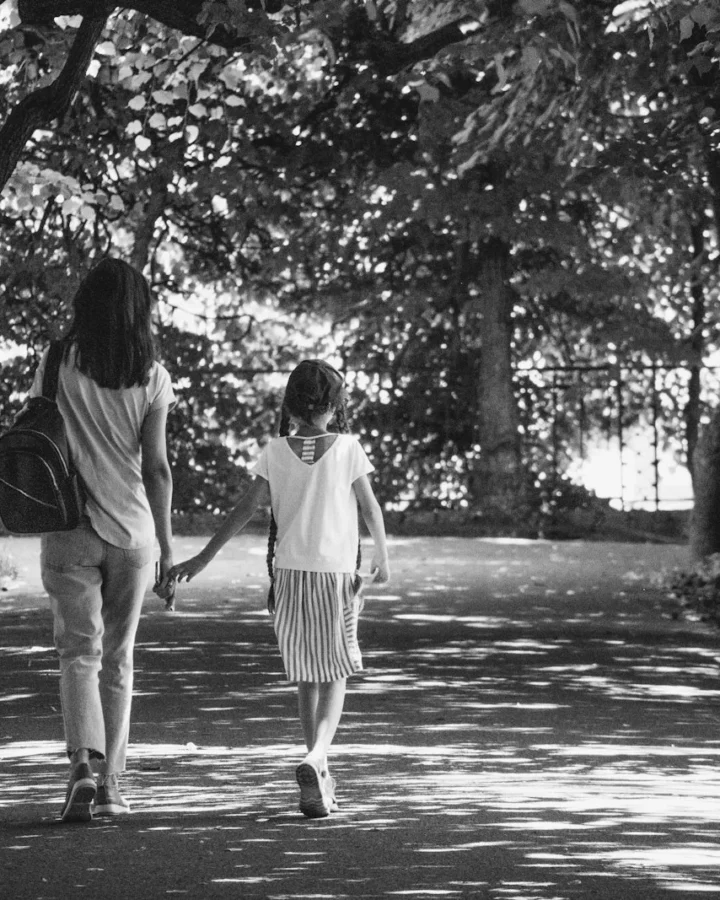 Una mujer y un niño caminando por un sendero arbolado
