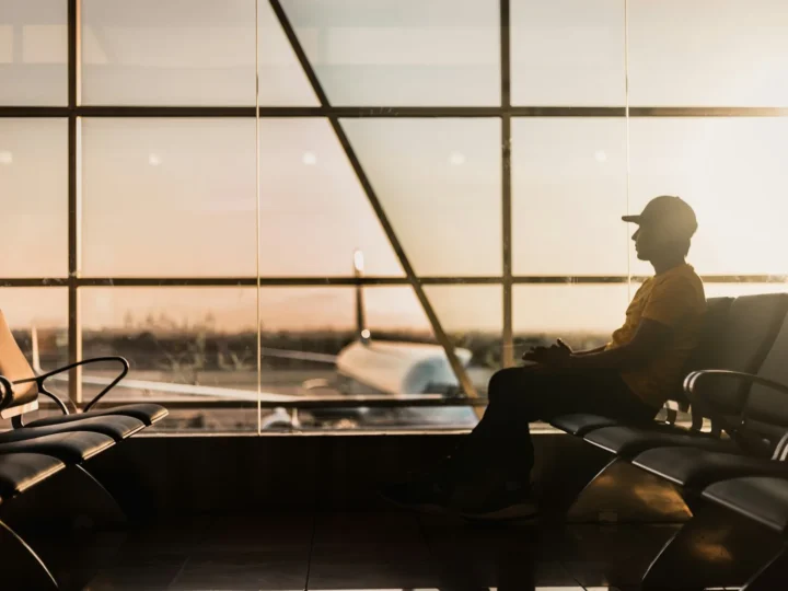 Viajero esperando junto al ventanal del aeropuerto